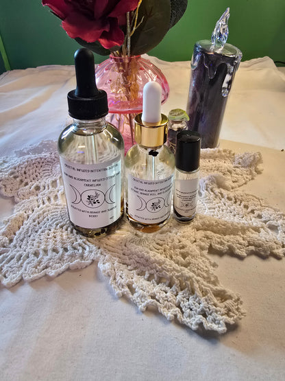 Three glass bottles filled with clear body oil with herbs on a white crochet mat and white table cloth