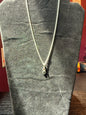 Sterling silver chain resting on a black velvet jewelry stand holding a stacked watermelon tourmaline pendant