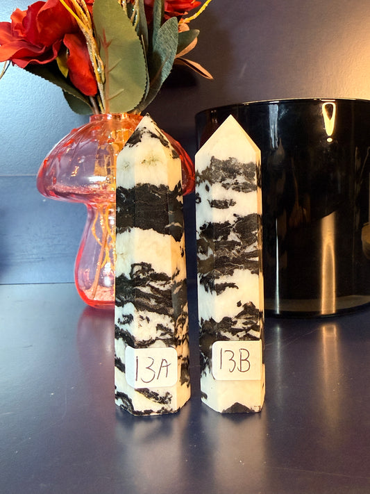 Two zebra patterned crystal towers in front of a mushroom vase and black jar