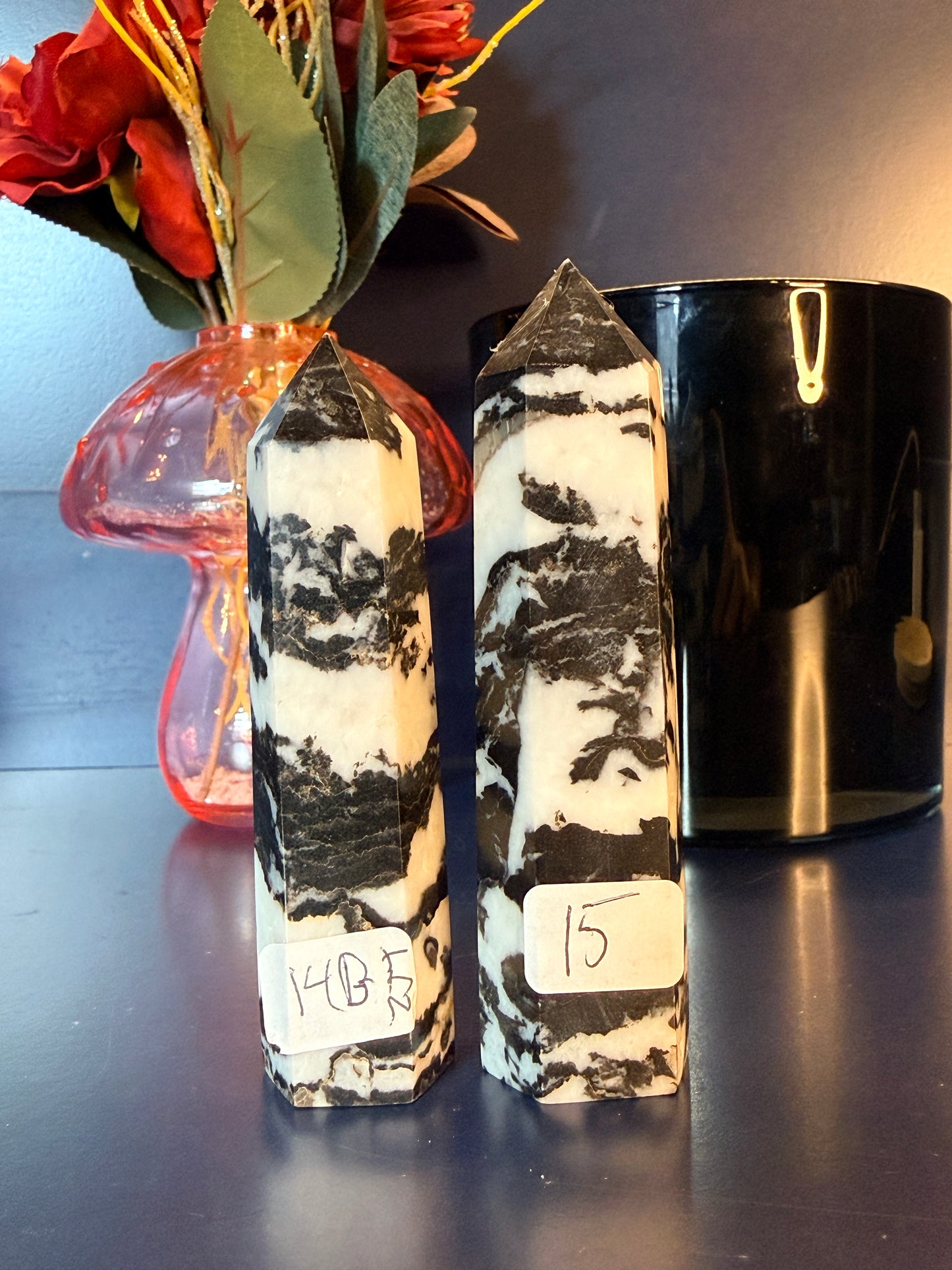 Two zebra patterned crystal towers in front of a mushroom vase and black jar
