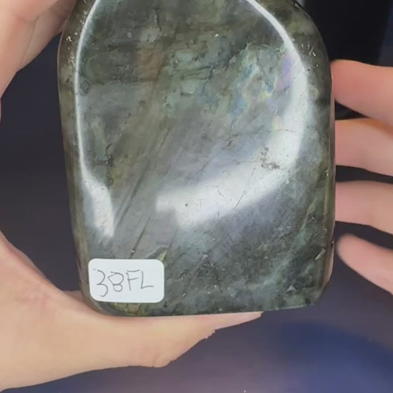 Two hands showing the purple sunset flash on large labradorite free forms